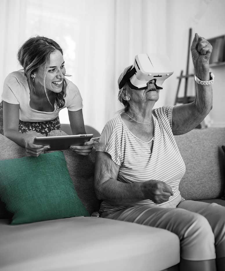 caregiver with senior woman using VR headset