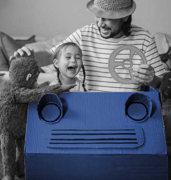 father and child in cardboard car