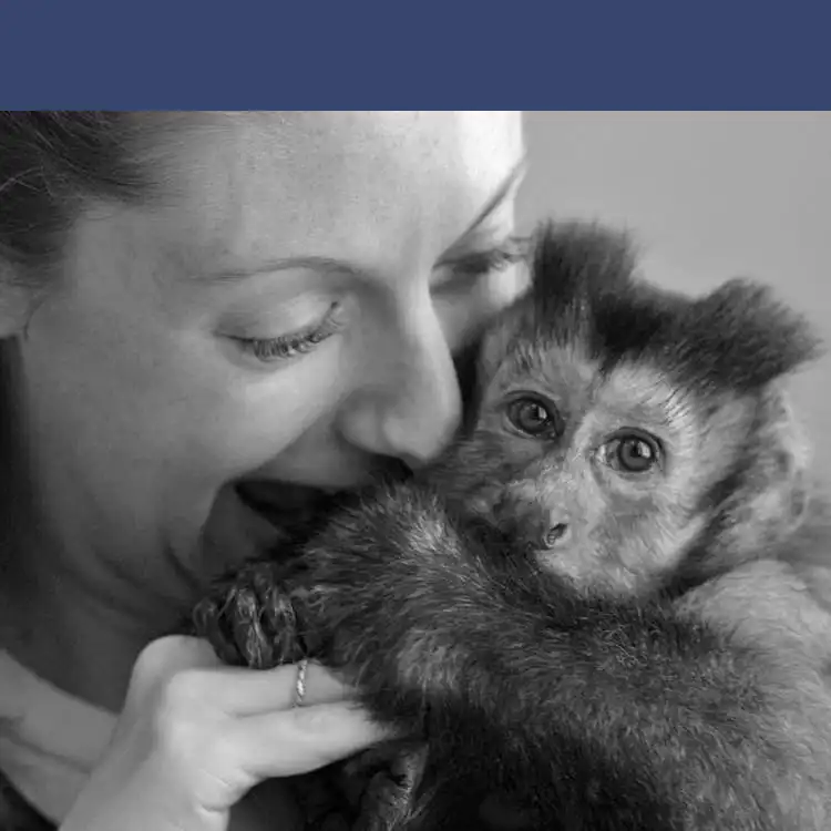 woman cuddling a monkey